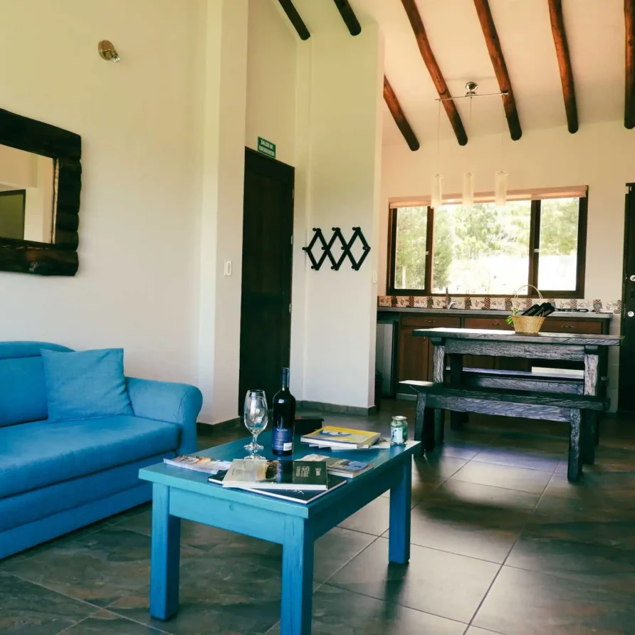 Sala y comedor acogedores de Casa Zuetana en Zipaquirá, con sofá azul, mesa de centro y mobiliario rústico de madera.