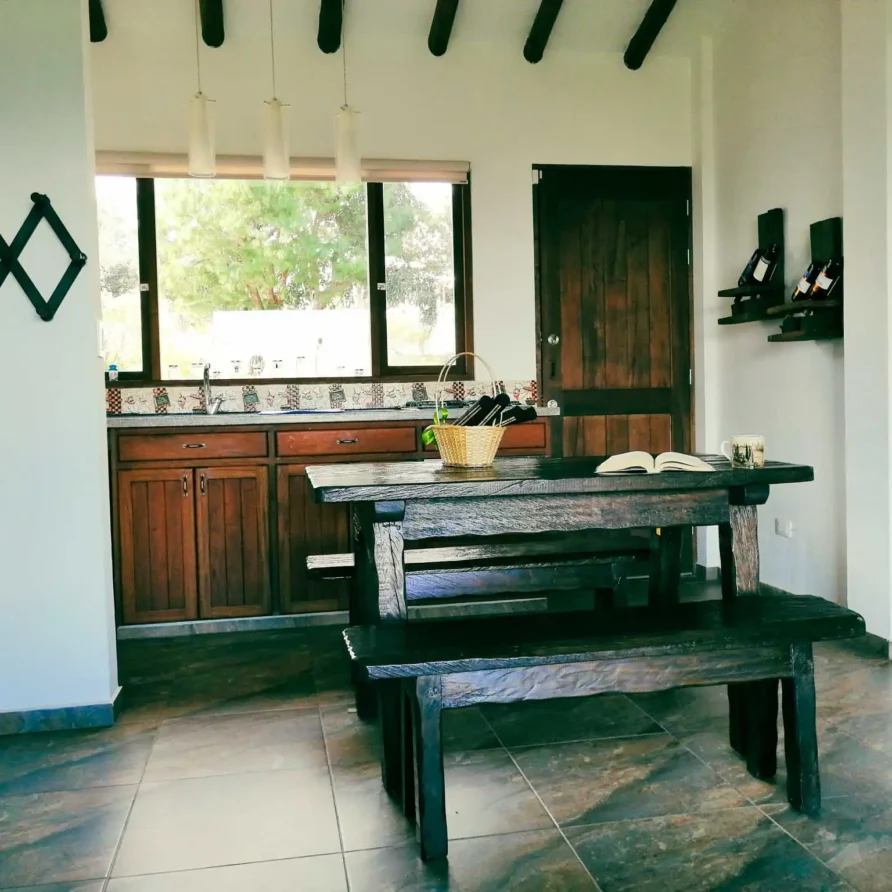 Comedor y cocina rústica de Casa Zuetana, alquiler vacacional en Zipaquirá. Ambiente acogedor con muebles de madera.