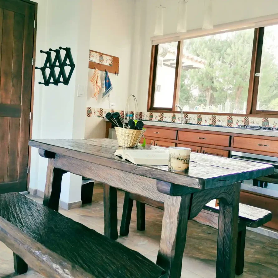 Mesa y bancos de madera rústicos en comedor de casa Zuetana, Zipaquira, ideal para alquiler vacacional.