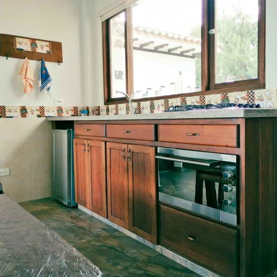 Interior acogedor de casa en Zipaquirá: cocina completa con muebles de madera, electrodomésticos modernos y decoración de chef.