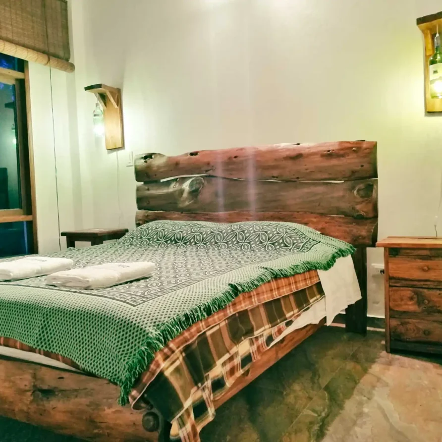 Dormitorio rústico Casa Zuetana en Zipaquirá con cama de madera natural y decoración acogedora para alquiler vacacional.