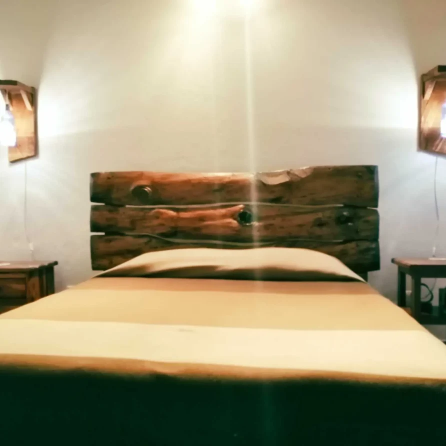 Dormitorio acogedor en casa de alquiler vacacional en Zipaquirá, con cama doble, mesitas y decoración rústica de madera.