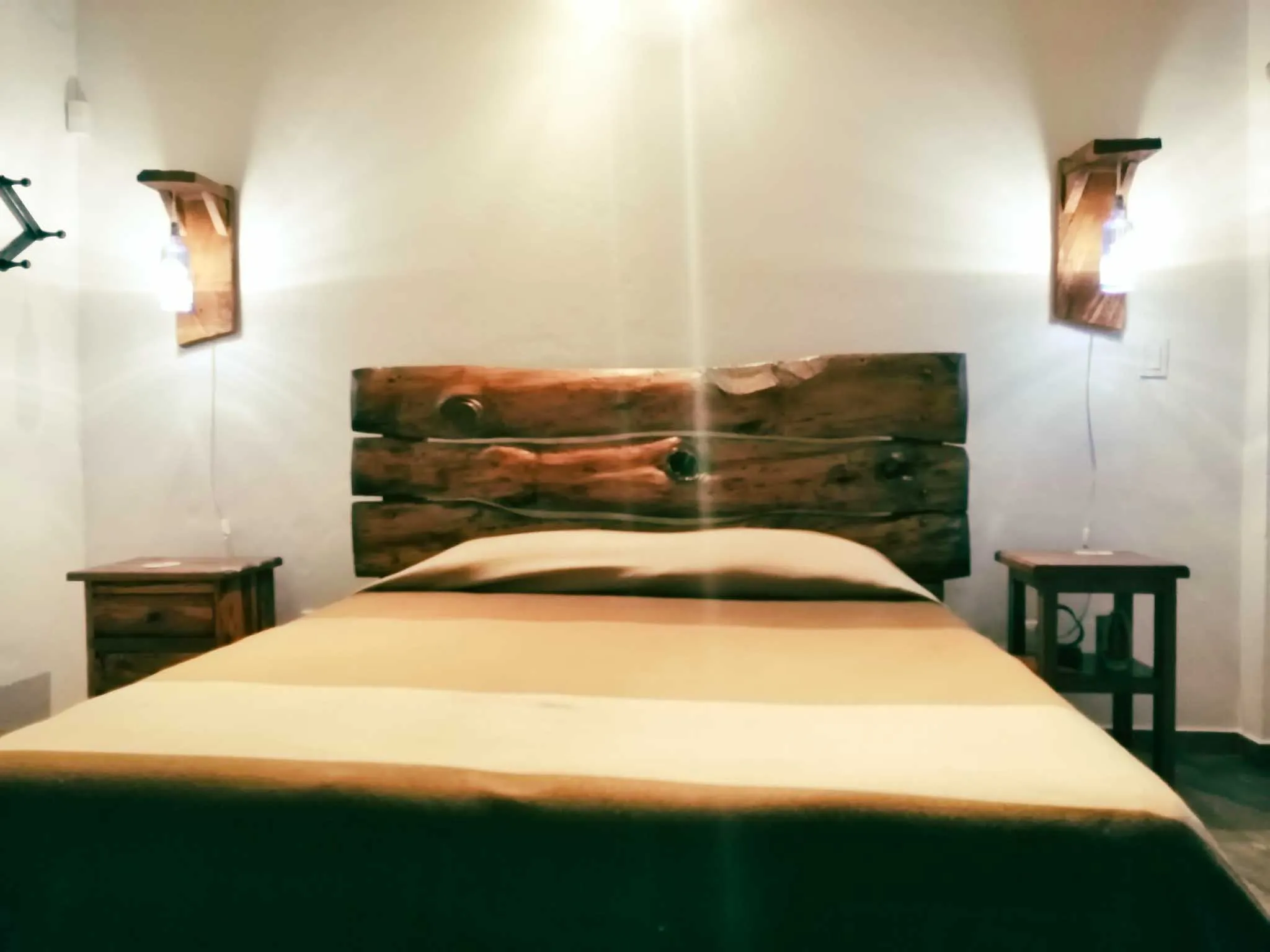 Dormitorio acogedor en casa de alquiler vacacional en Zipaquirá, con cama doble, mesitas y decoración rústica de madera.