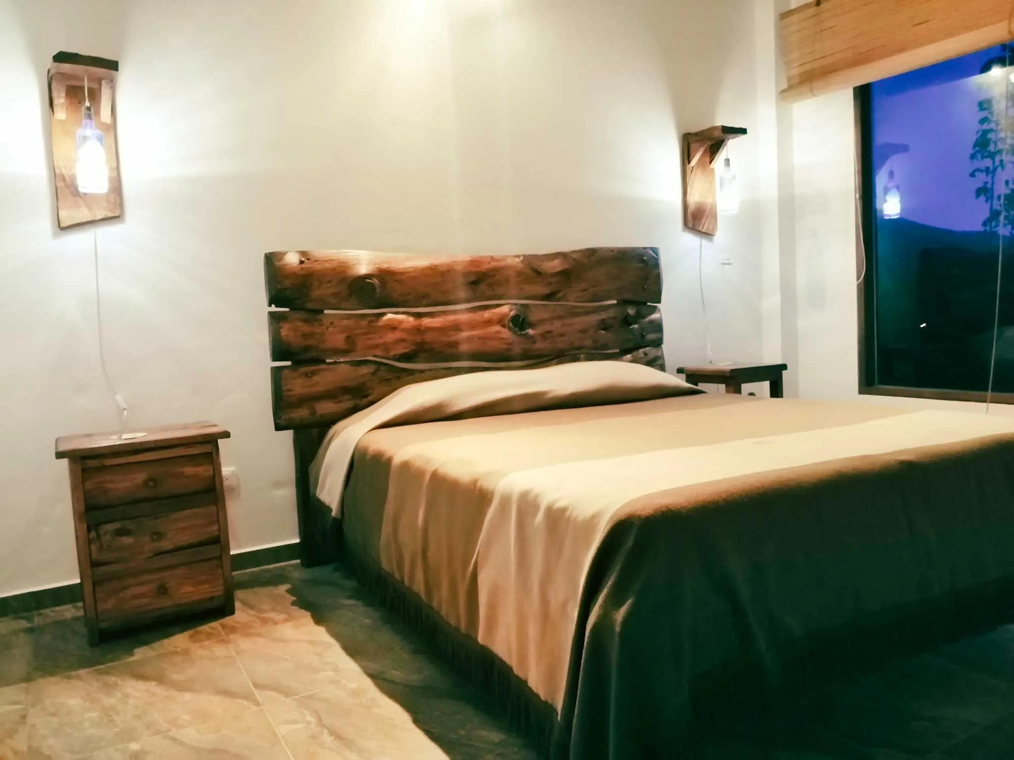 Dormitorio rústico en Casa Zuetana, Zipaquirá, con cabecero de madera natural y detalles acogedores.
