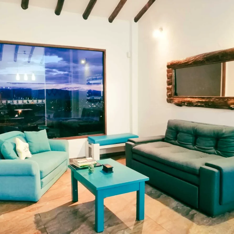 Salón-comedor moderno y rústico en Casa Zuetana, cerca de Zipaquirá, ideal para vacaciones con chimenea y ambiente cálido.