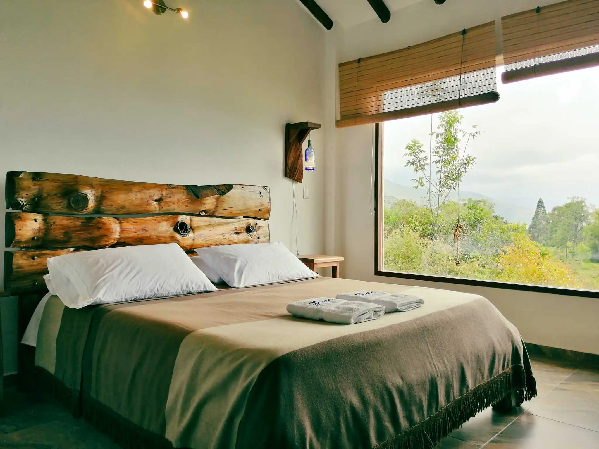 Dormitorio acogedor de alquiler vacacional en Zipaquira, con cama doble y decoración de madera, vista a la naturaleza.
