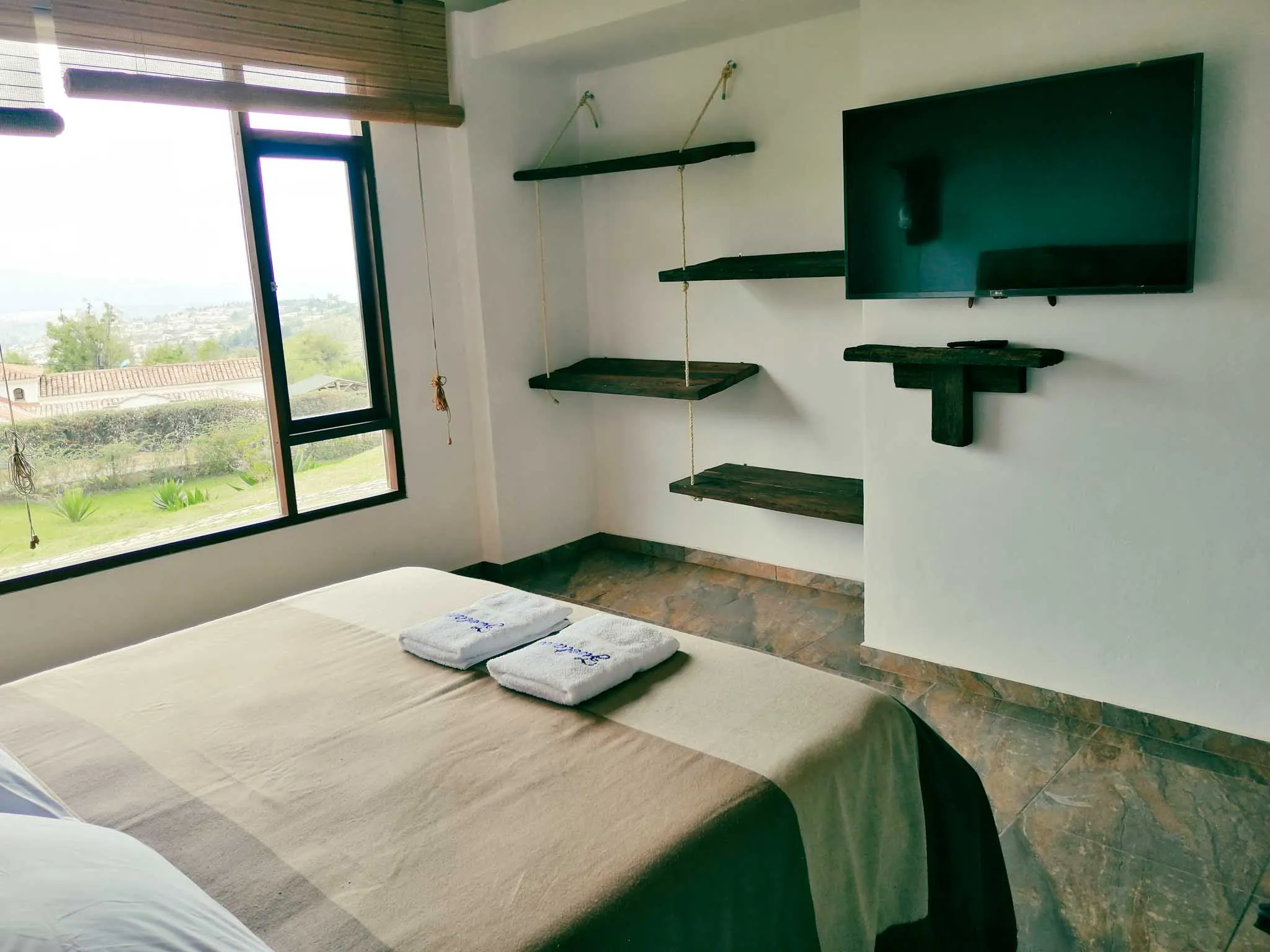 Hermosa habitación en Casa Zuetana cerca de Zipaquira, con cama confortable, detalles rústicos y panorámica verde.