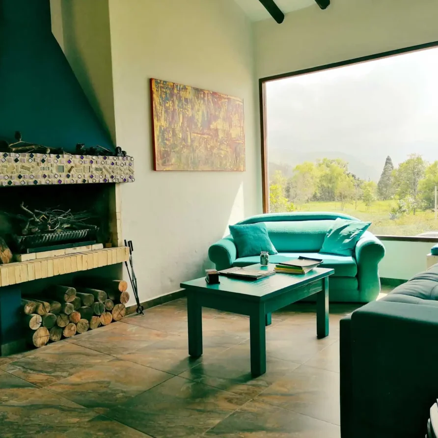 Sala principal de Casa Zuetana con diseño rústico-moderno, vigas de madera y ventanal panorámico.