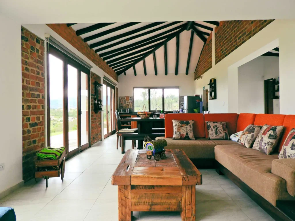 Interior moderno y rústico de la Casa Hichatana en Zipaquirá, con sala de estar, cocina integrada y grandes ventanales.