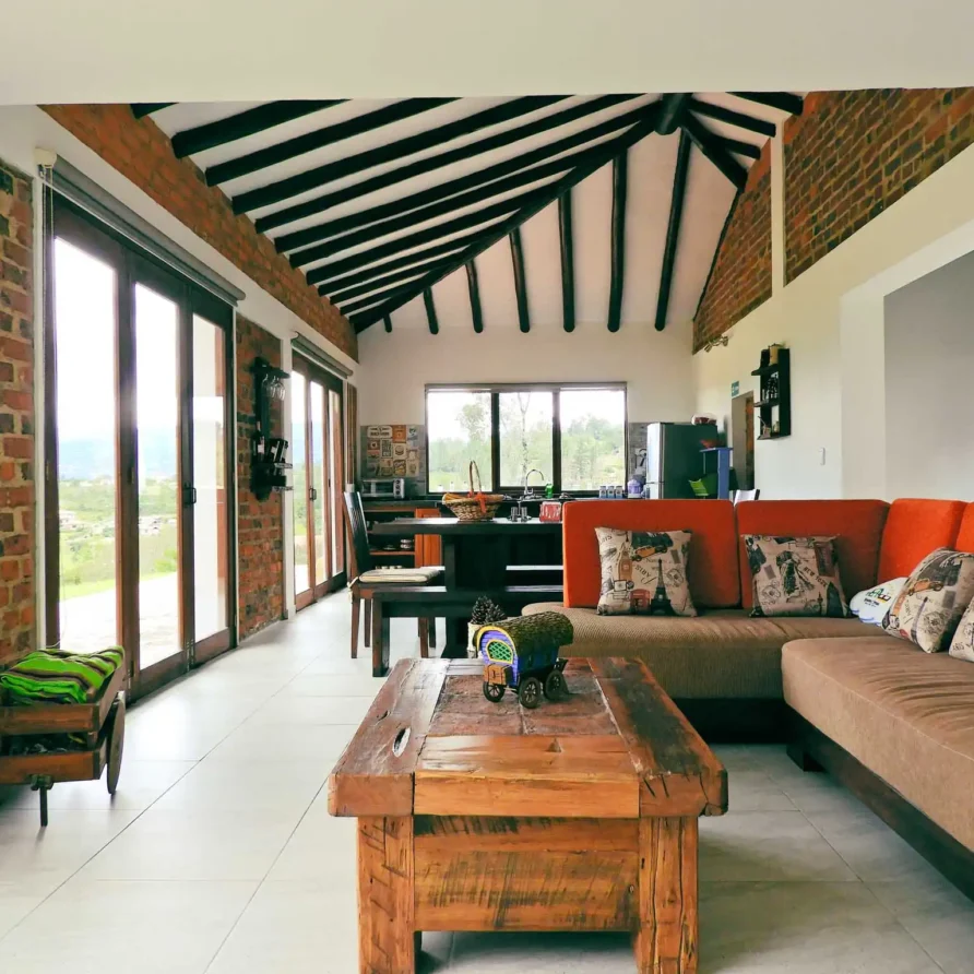 Interior moderno y rústico de la Casa Hichatana en Zipaquirá, con sala de estar, cocina integrada y grandes ventanales.