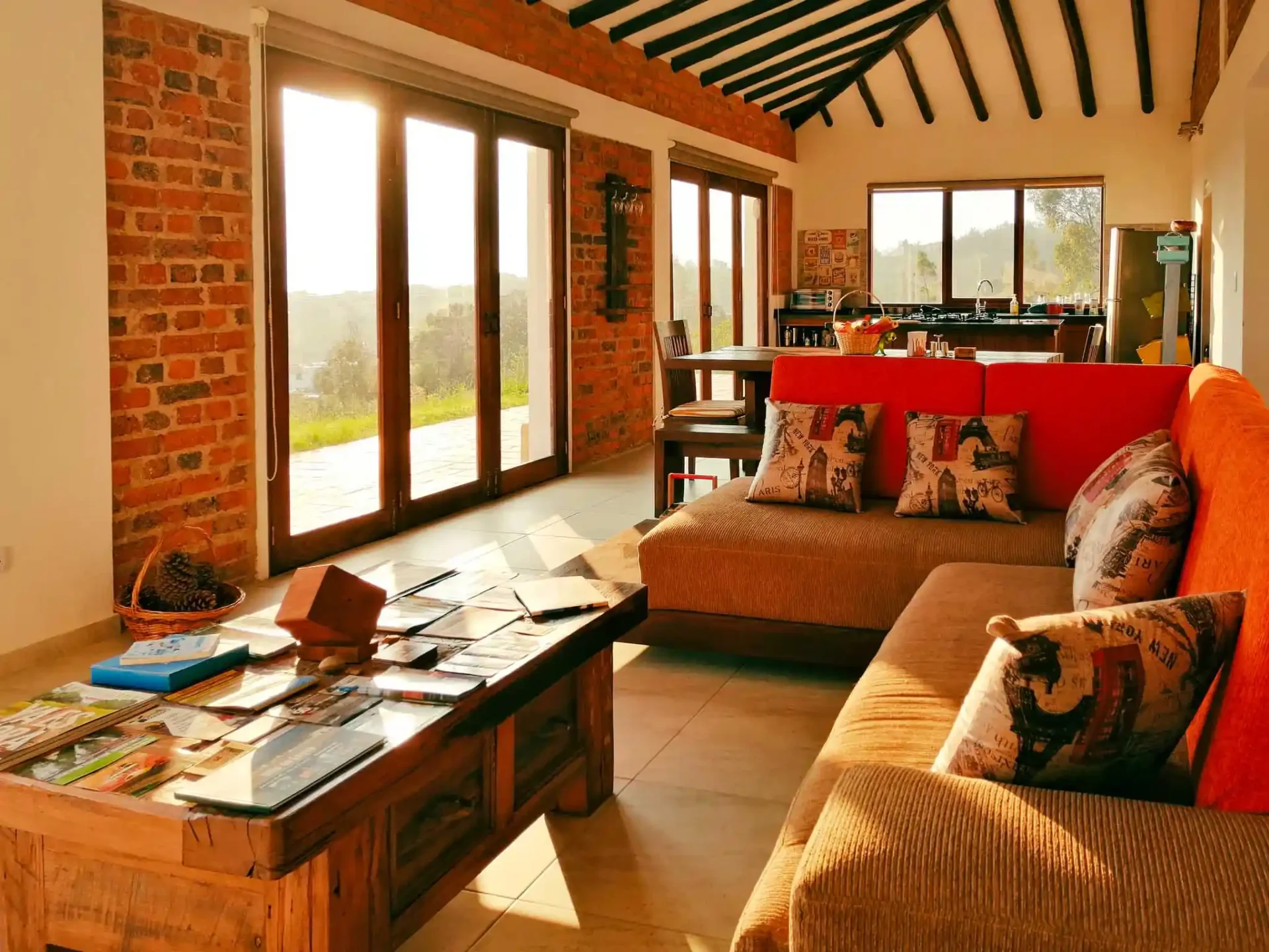 Interior acogedor de casa de alquiler en Zipaquirá con grandes ventanales, techo con vigas y mobiliario rústico de madera.