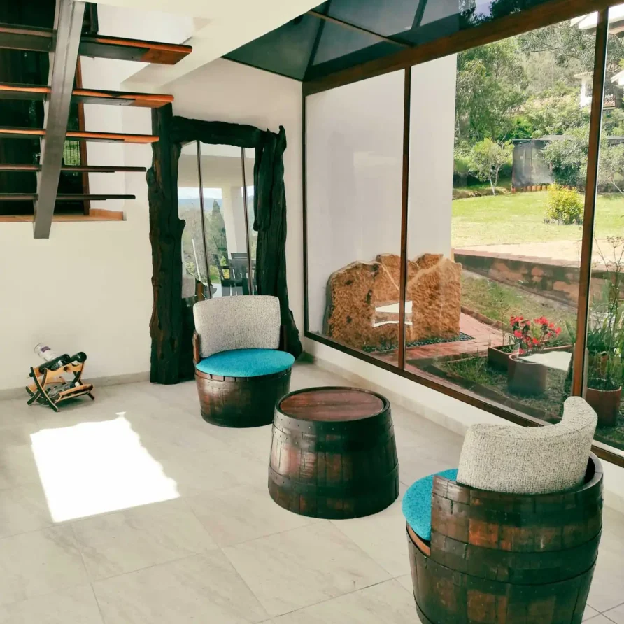 Interior luminoso y rústico de una casa de alquiler vacacional en Zipaquirá, con escalera y vistas naturales.