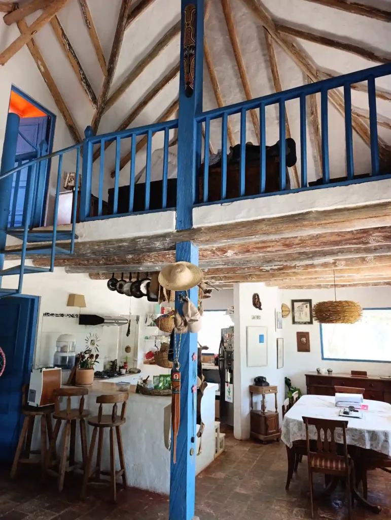 Interior de Cabaña el Ensueño en Villa de Leyva con loft, escaleras azules y diseño rústico de vigas de madera.