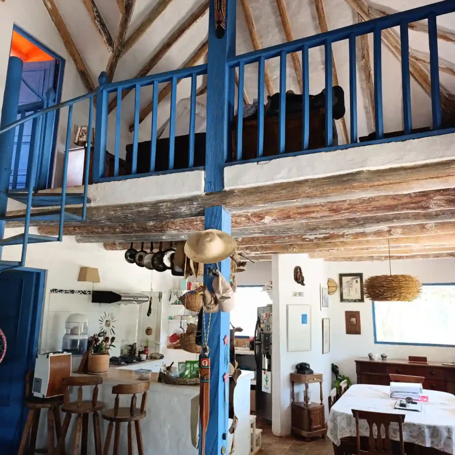 Interior de Cabaña el Ensueño en Villa de Leyva con loft, escaleras azules y diseño rústico de vigas de madera.