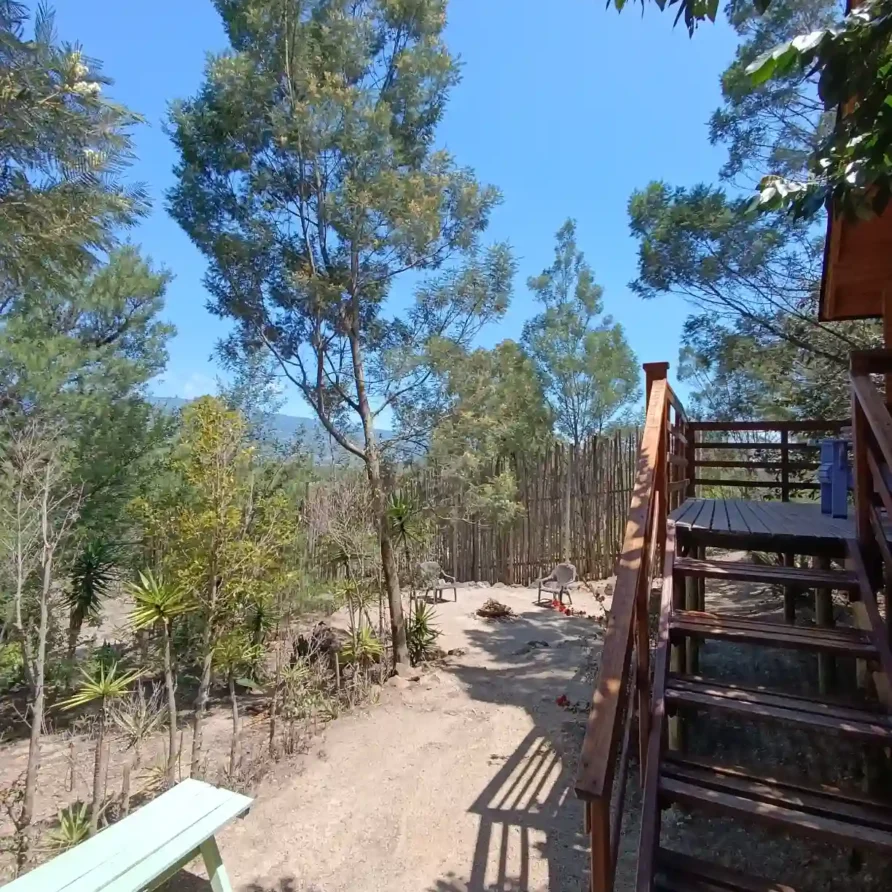 Zona de descanso natural al aire libre con sillas y mesa rústica en Cabaña El Ensueño, Villa de Leyva.