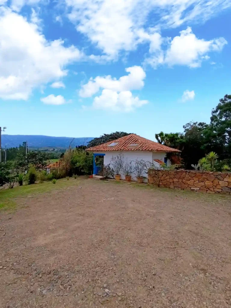 Hermosa casa de campo El Oteo en Villa de Leyva, bajo un cielo azul con nubes, ideal para hospedaje rural.