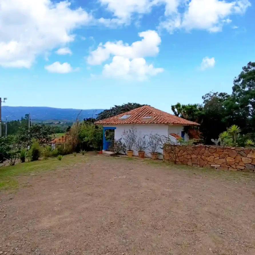 Hermosa casa de campo El Oteo en Villa de Leyva, bajo un cielo azul con nubes, ideal para hospedaje rural.