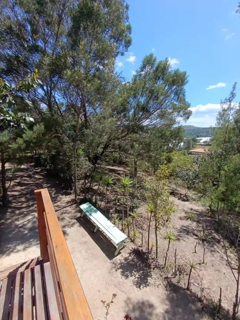 Paisaje natural de hospedaje premium en Villa de Leyva, mostrando un área de descanso entre vegetación y vistas.