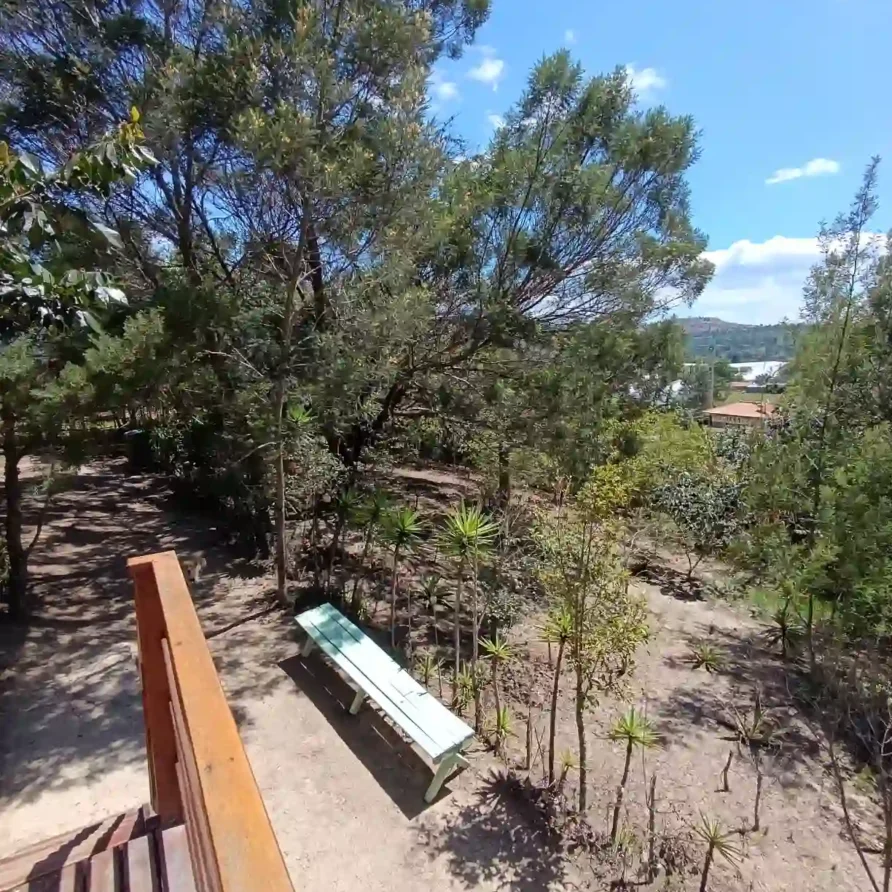 Paisaje natural de hospedaje premium en Villa de Leyva, mostrando un área de descanso entre vegetación y vistas.