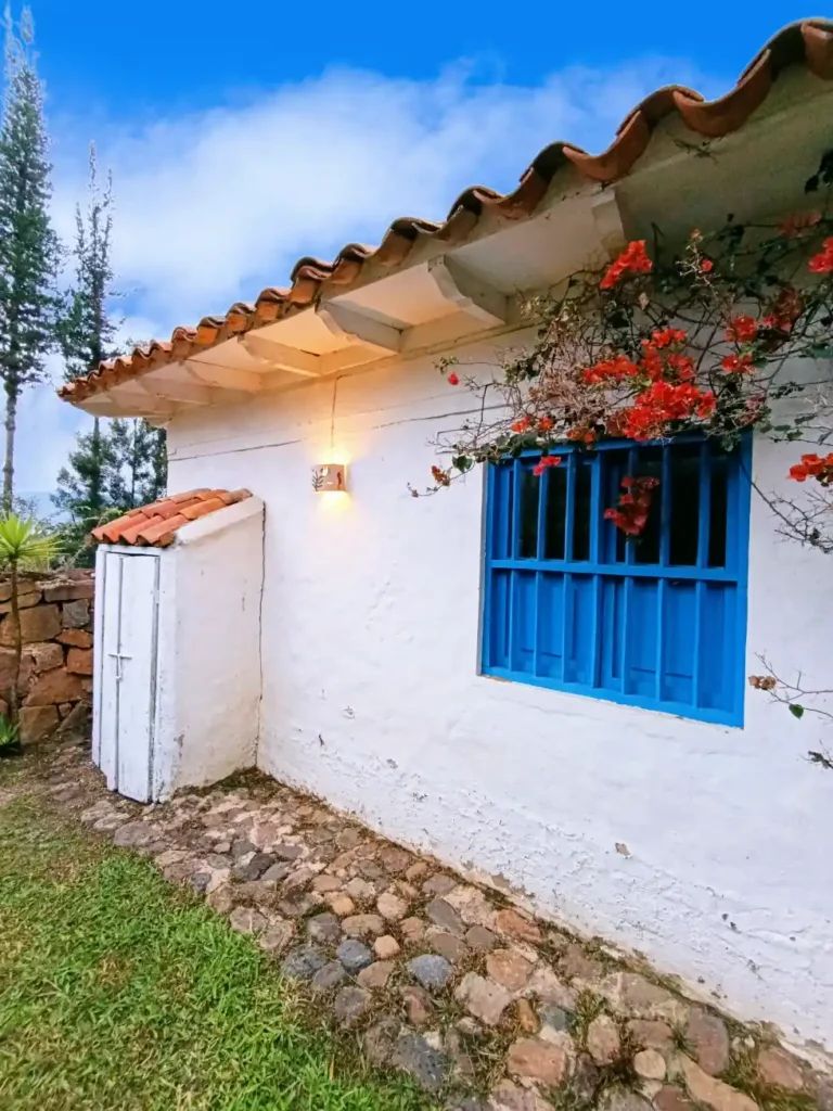 Vista lateral de una encantadora cabaña con detalles tradicionales, perfecta para un retiro en Villa de Leyva.