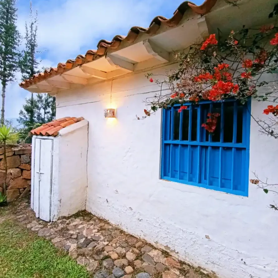 Vista lateral de una encantadora cabaña con detalles tradicionales, perfecta para un retiro en Villa de Leyva.