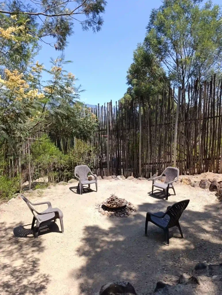 Zona de fogata exterior con cuatro sillas en la Cabaña el Ensueño, Villa de Leyva. Entorno natural y privado para descanso en hotel Hichatana y Zuetana.