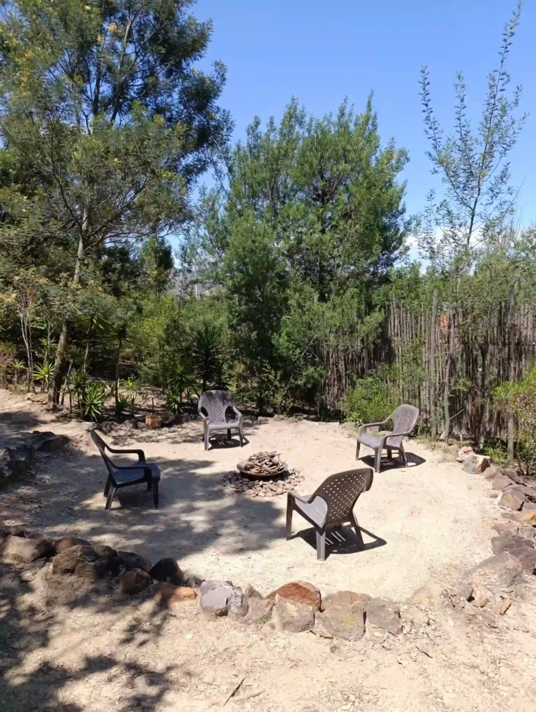 Patio con fogata central y sillas, perfecto para desconectar en un hospedaje natural de Villa de Leyva. Ambiente tranquilo.