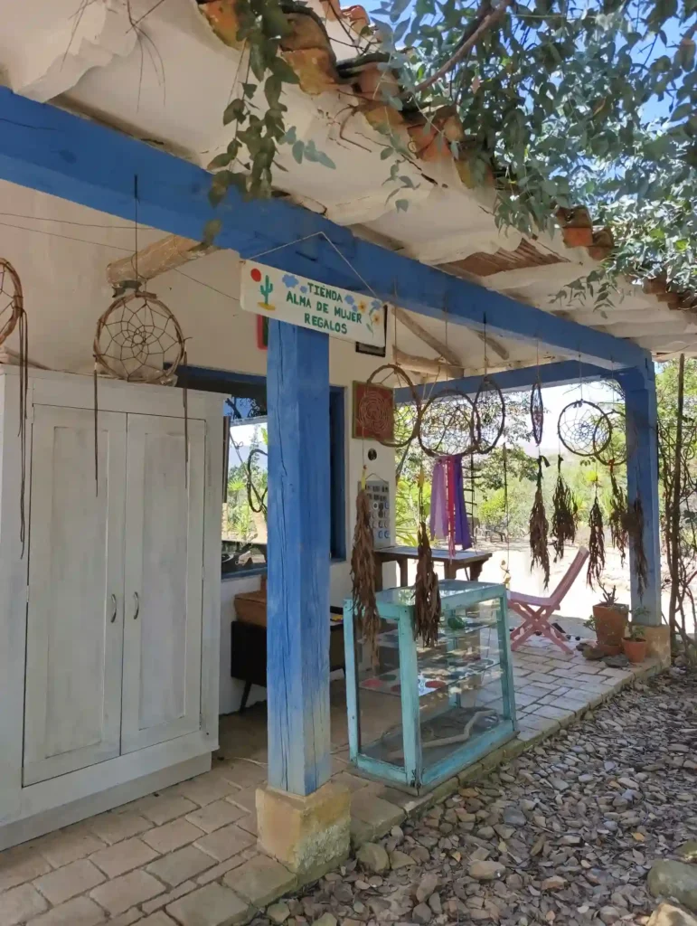 Fachada rústica de la Tienda Alma de Mujer en una cabaña de Villa de Leyva, con vigas azules y atrapasueños.