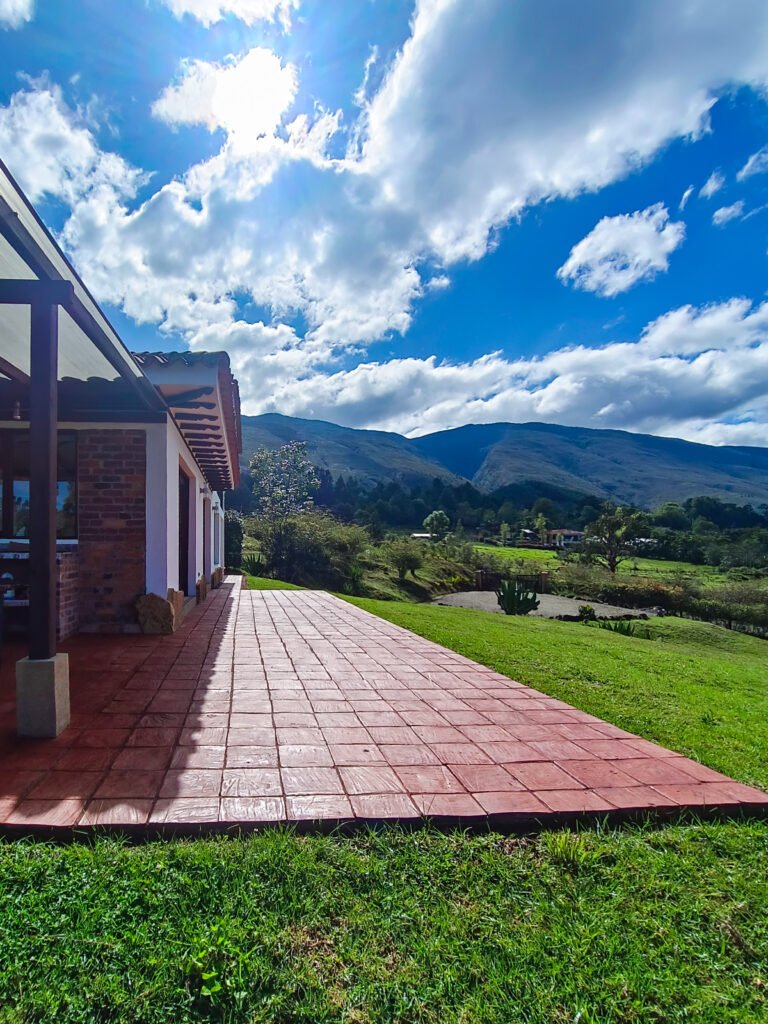 Casa de alquiler vacacional en Villa de Leyva con jardín y camino de ladrillo.