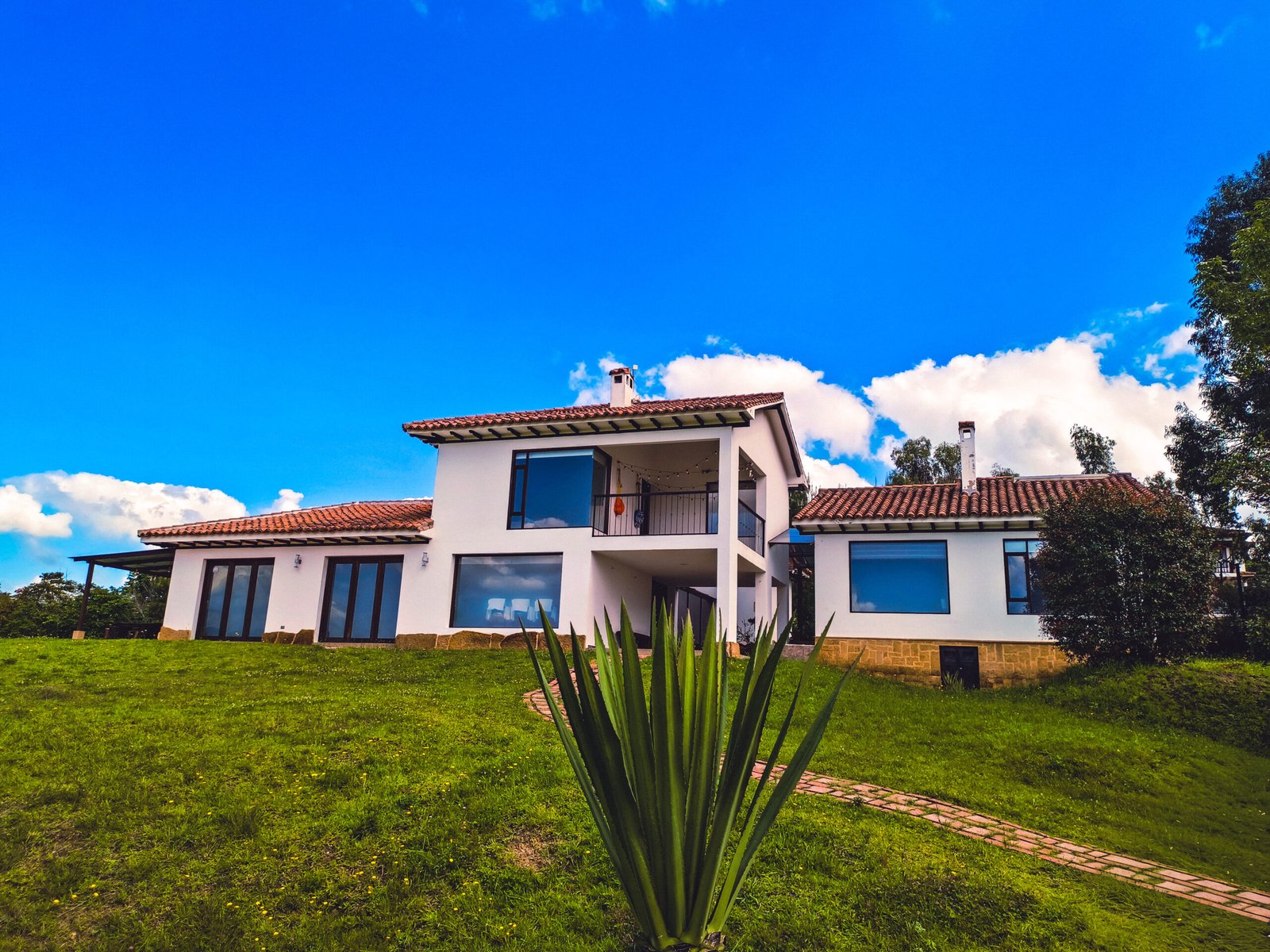 Exterior de casa rural con tejas rojas en Zipaquirá, rodeada de naturaleza.