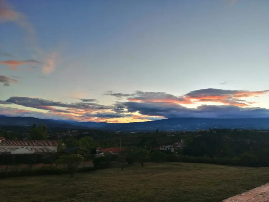 Paisaje rural de Villa de Leyva al atardecer con casas y montañas.