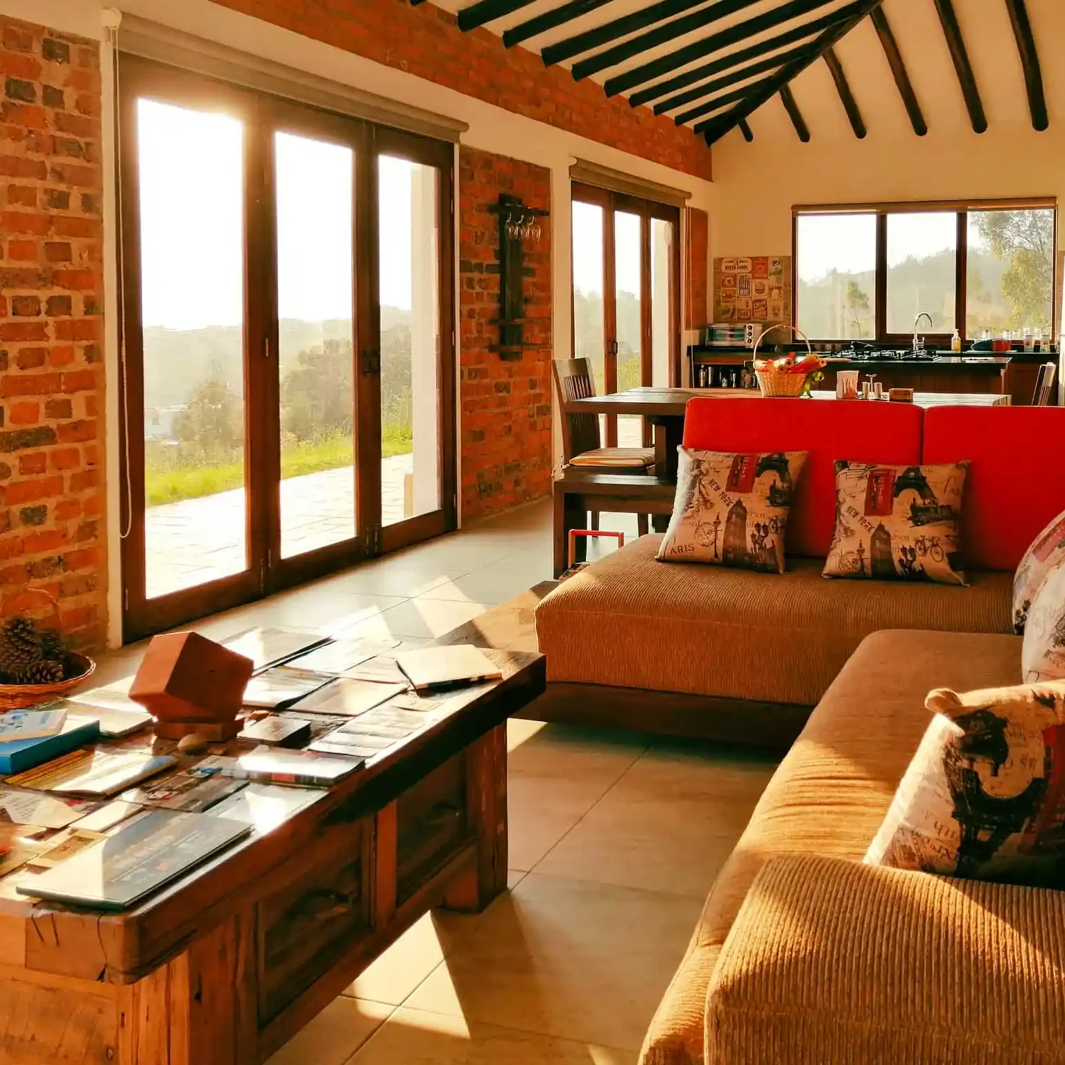 Interior acogedor de casa de alquiler en Zipaquirá con grandes ventanales, techo con vigas y mobiliario rústico de madera.